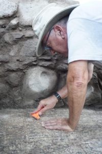 Mordechai Aviam cleaning the inscription. Courtesy Zachary Wong, El-Araj Expedition.